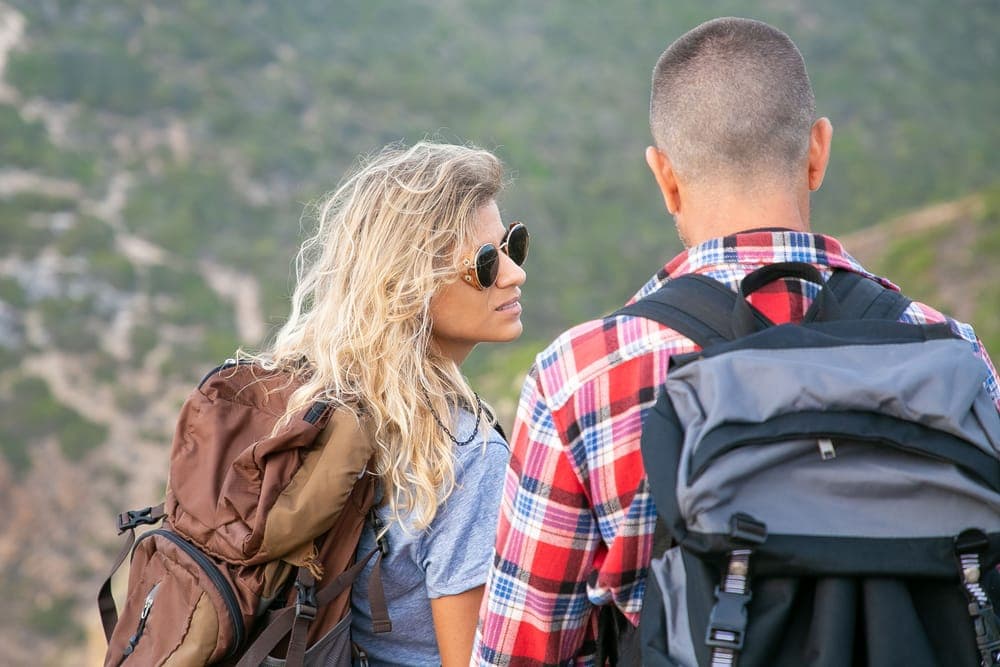 Two hikers with backpacks on a coastal trail